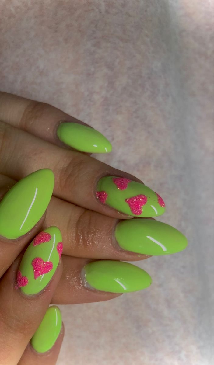 Playful Pink Heart Designs on Vibrant Green Nails: A Fun and Cheerful Nail Art Concept.