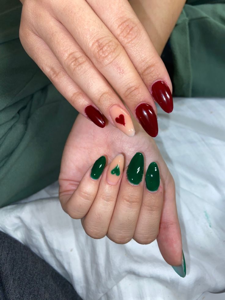 Festive Nail Design: Cheerful Deep Red and Rich Green with Heart Motifs on Nude Base.