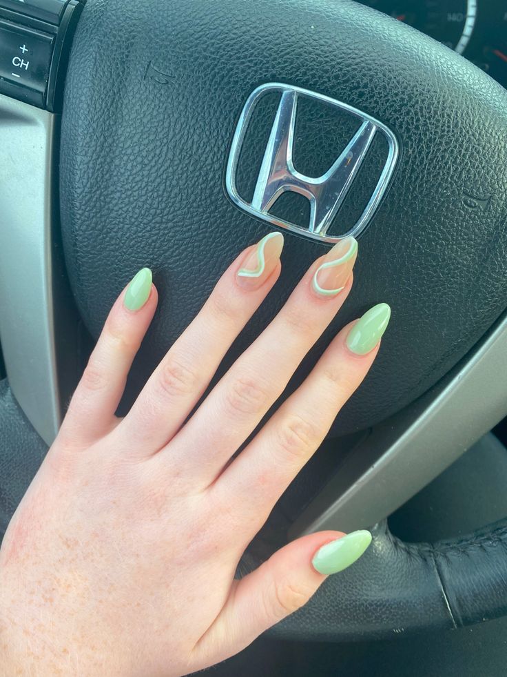 Chic Almond-Shaped Nails with Pastel Green Polish and Wavy White Accents