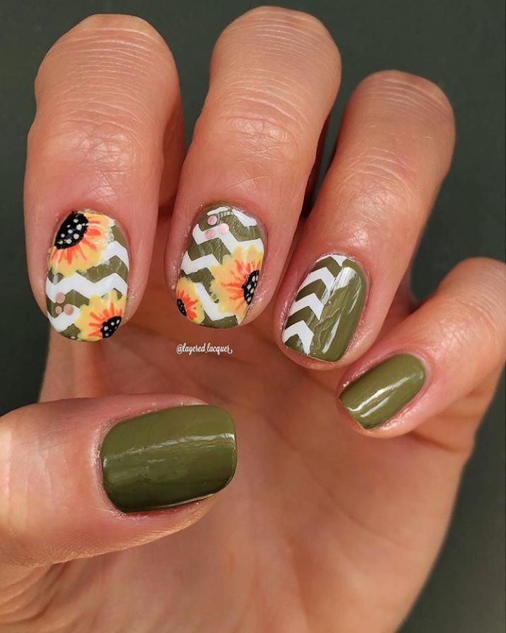 Playful Floral and Geometric Nail Design with Sunflowers and Chevron Stripes on Olive Green Base.