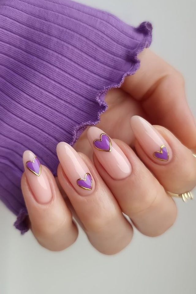 Delightful Pink Heart Nail Design with Vibrant Purple Accents and Gold Detailing.