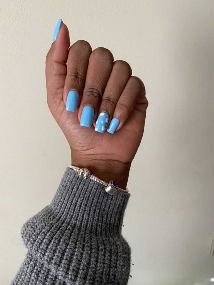 Charming Soft Blue Nail Design with Playful Polka Dot Accents.