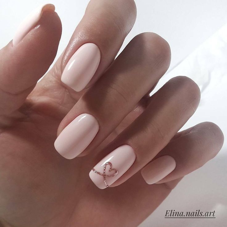 Chic Soft Pink Nail Design with Rose Gold Heart Accent for Modern Elegance.