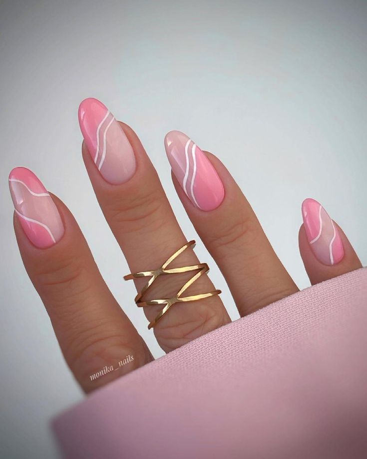 Sophisticated Pink Gradient Nail Design with White Swirls and Chic Gold Accents.