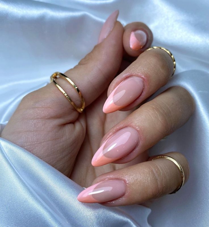 Chic Almond-Shaped Nails with Soft Pink Ombre and Glossy Finish, Accented by Gold Rings.