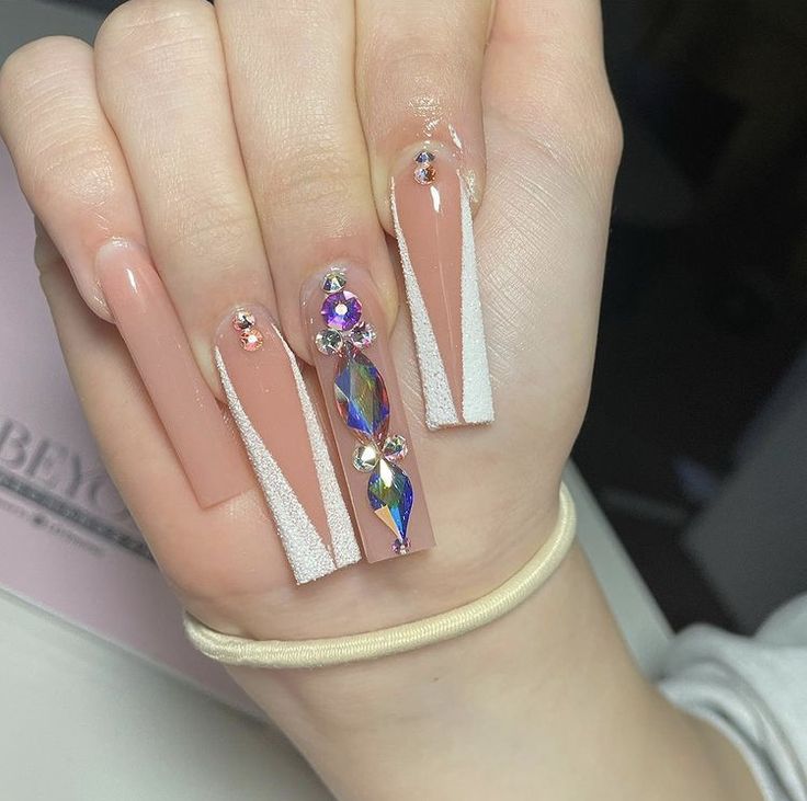 Sophisticated Nude Nails with Geometric Designs and Festive Gem Accents.