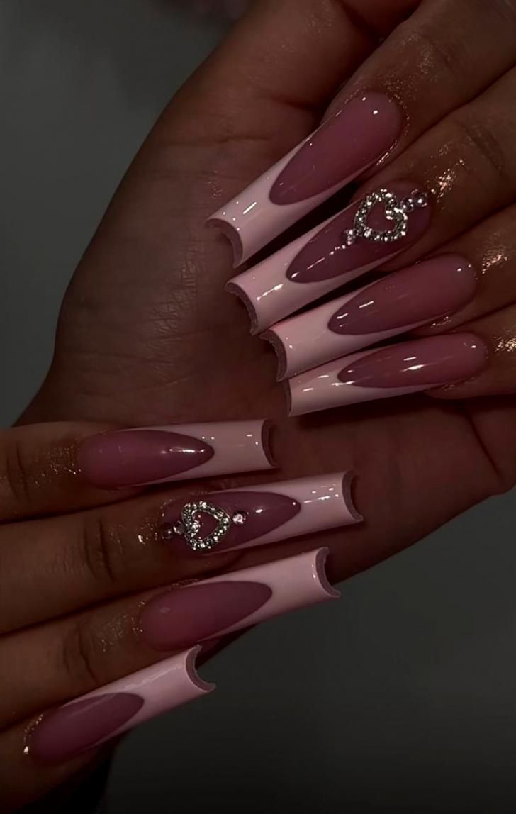 Chic Ombre Nail Design: Soft Pink and Nude Hues with Heart-Shaped Rhinestones.