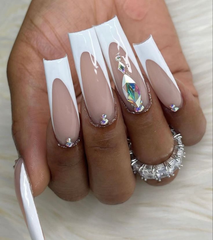 Chic White and Nude Nail Design with Sparkling Rhinestones and Elegant Negative Space Elements.