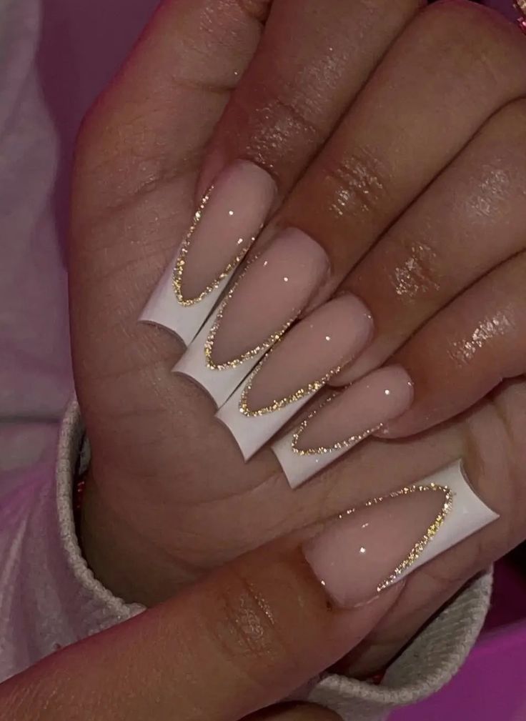 Sophisticated Nude Nail Design with Elegant White Tips and Gold Glitter Accents.