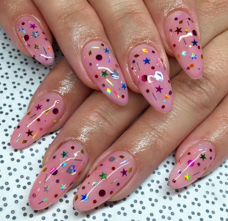 Playful Geometric Nail Design with Soft Pink Base and Star Glitter Accents.