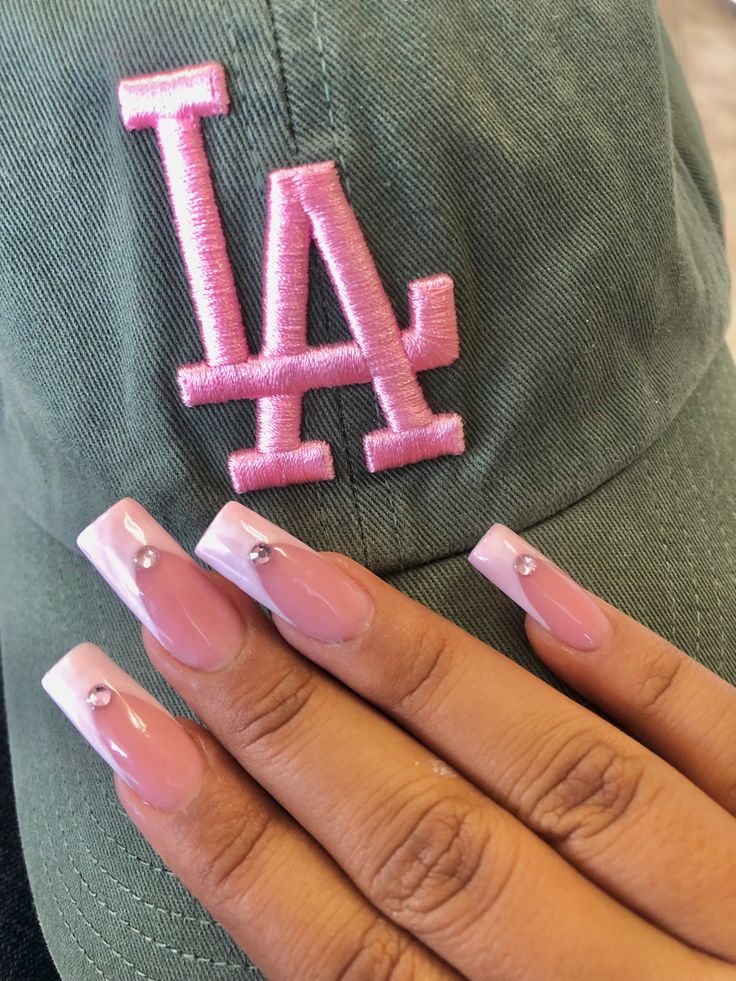 Chic Soft Pink Nail Design with White Tips and Rhinestones for a Trendy Look.