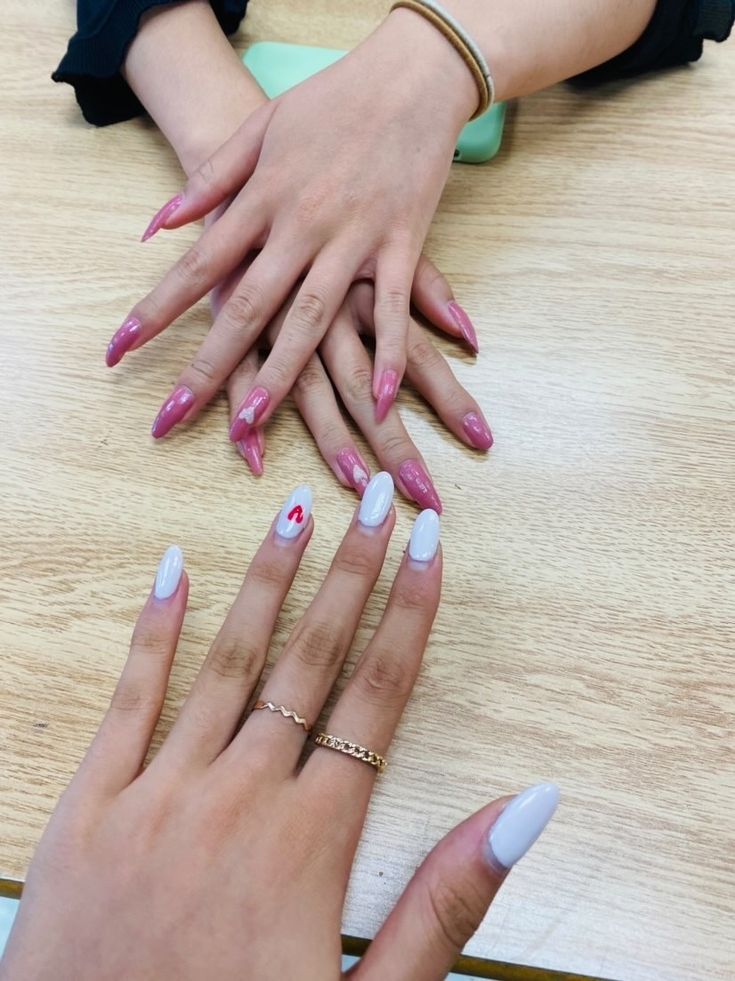 Chic Nail Designs: A Stylish Blend of Pointed Pink, Pastel Blue, and Playful Accents.