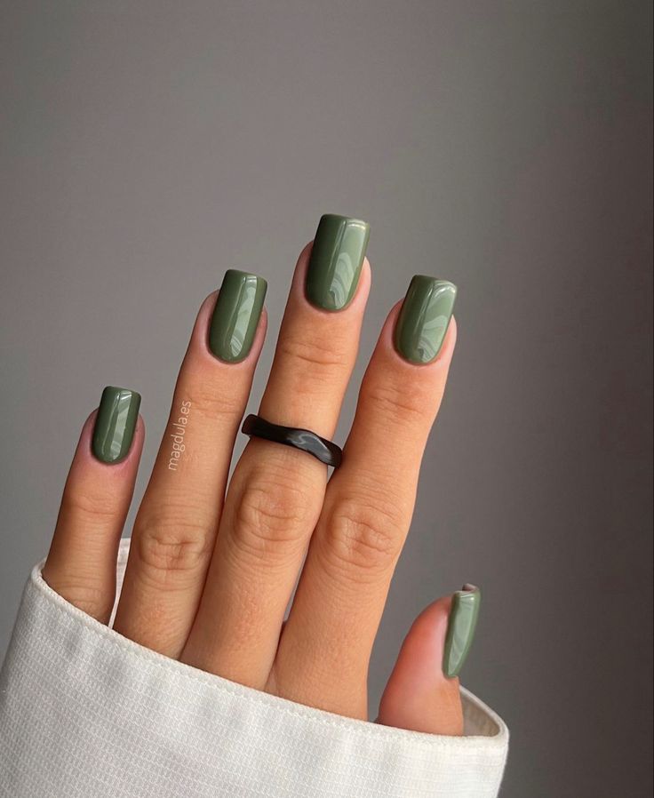 Elegant Green Nail Design with Glossy Finish and Textured Depth, Accented by a Chic Black Ring.