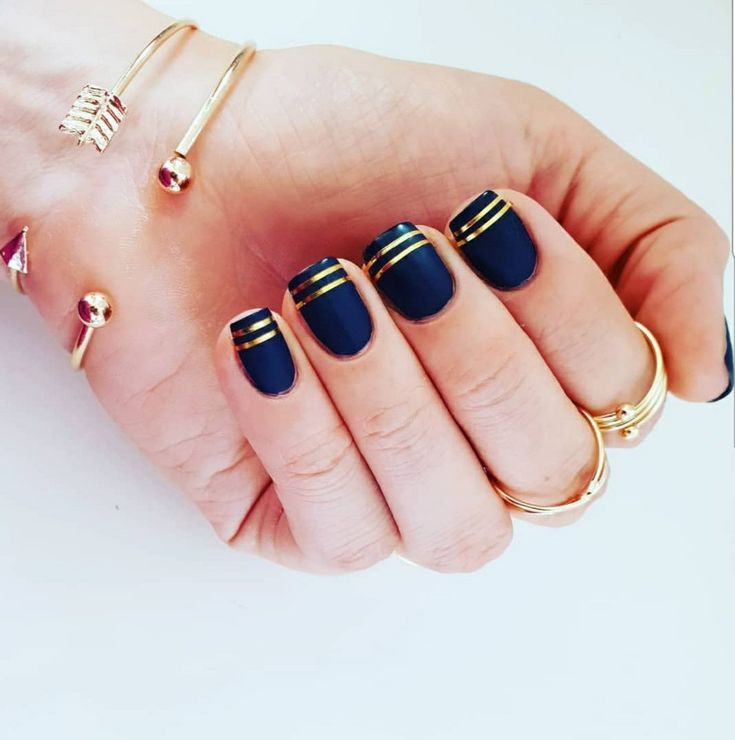 Elegant Navy Blue and Gold Striped Nail Design with Matte Finish for Versatile Occasions.