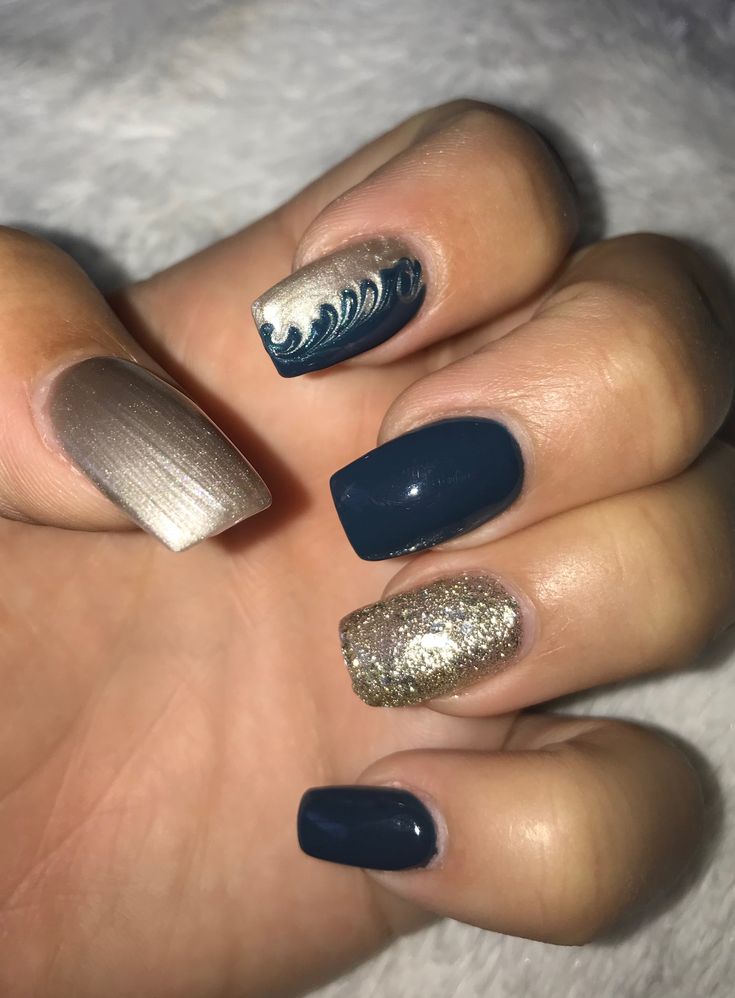 Playful Deep Blue and Metallic Gold Nail Design with Glitter and Wave Accents.