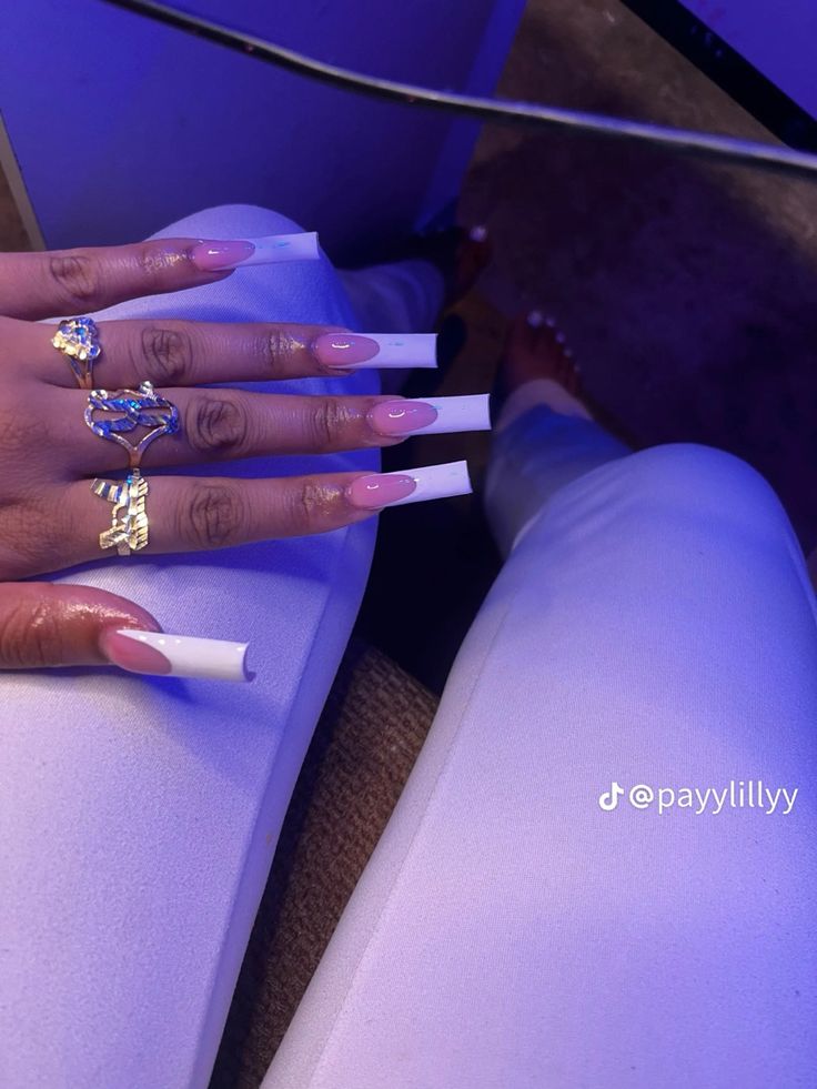 Chic French Manicure: Elegant Pink and White Long Nails Adorned with Glamorous Rings.