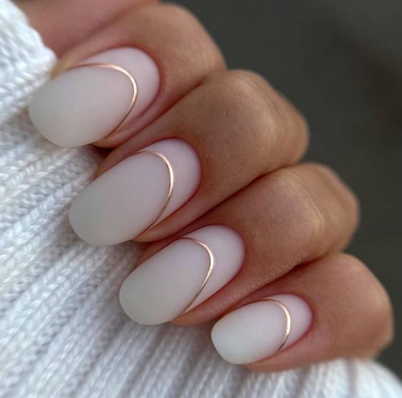 Chic Matte White Nails with Gold Accents for Modern Elegance.