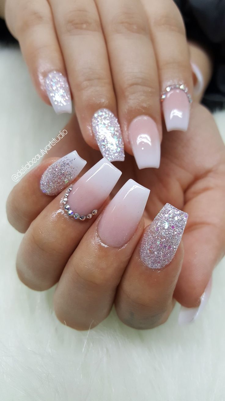 Glamorous Glossy Nude and Glitter Nail Design with Rhinestone Accents.