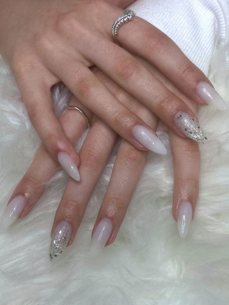 Chic Ombre Nail Design with Glitter Accents and Elegant Rings.