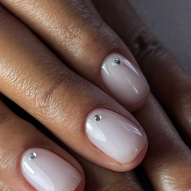 Elegant Nude Nails: Glossy Finish with Subtle Rhinestone Embellishments for Effortless Glam.