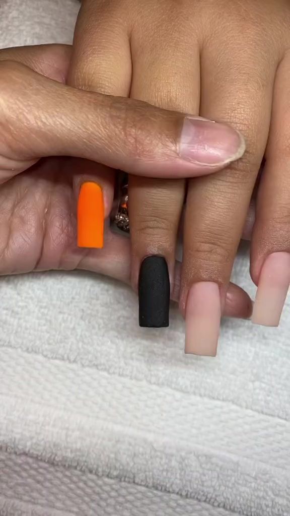 Bold Nail Design with Neon Orange Accent and Matte Black/Nude Finishes for Creative Statement.