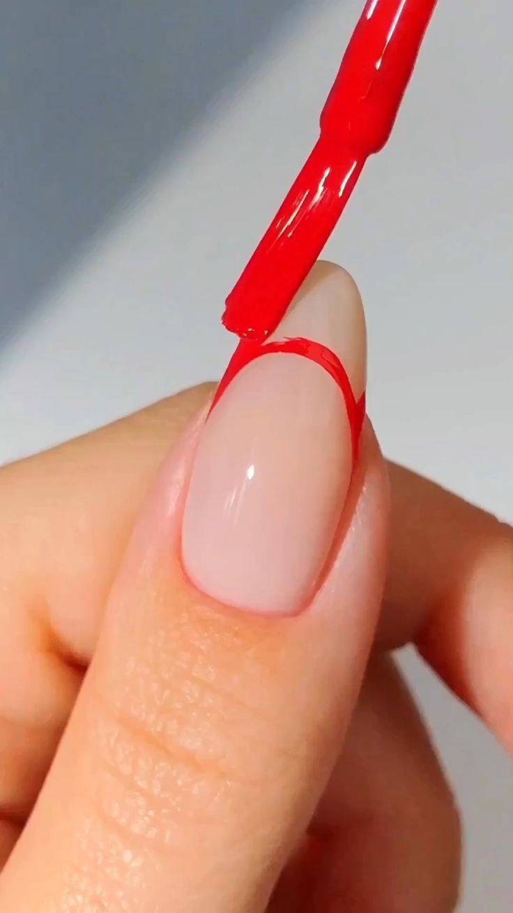 Chic Half-Moon Manicure: Elegant Glossy Nude Base with a Striking Red Accent.