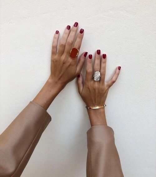 Sophisticated Elegance: Burgundy Manicure and Glamorous Statement Rings.