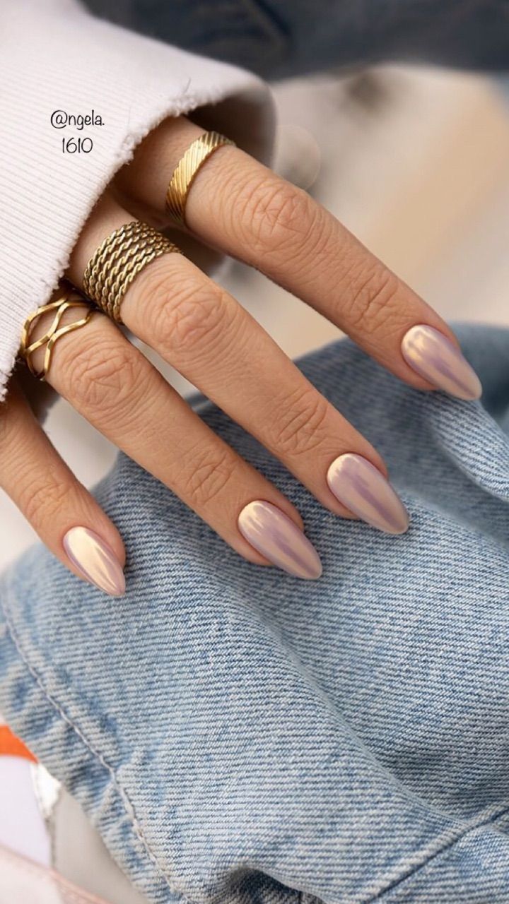 Sophisticated Almond-Shaped Nail Design with Subtle Shimmer and Gold Accents.