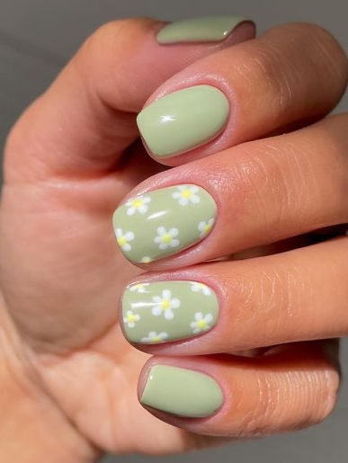 Charming Pastel Green Manicure with Delicate Floral Accents for a Whimsical Spring Look.