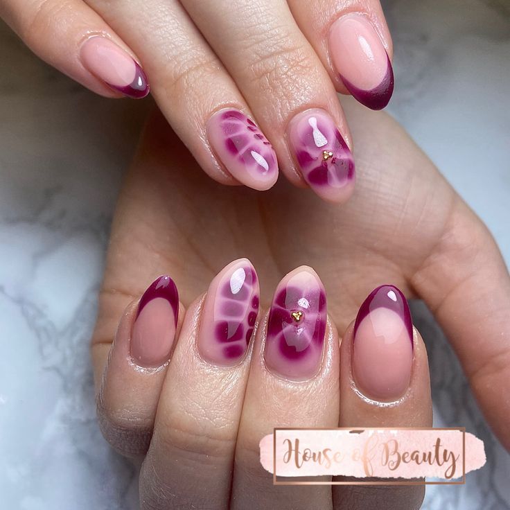 Chic Nail Art: Soft Pink and Burgundy French Tips with Artistic Patterns and Gemstone Accents.