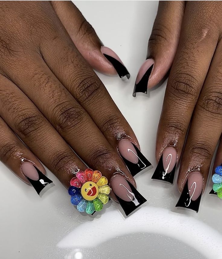 Bold and Whimsical Nude and Black Nail Design with Vibrant Flower Charms