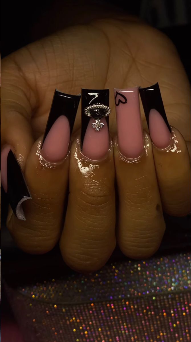 Chic Nail Design: Glossy Black Tips and Soft Pink Base with Elegant Embellishments.