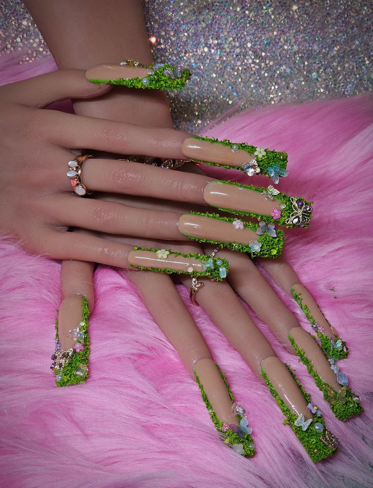 Whimsical Green-Themed Stiletto Nail Design with Floral Accents and Textured Finish.