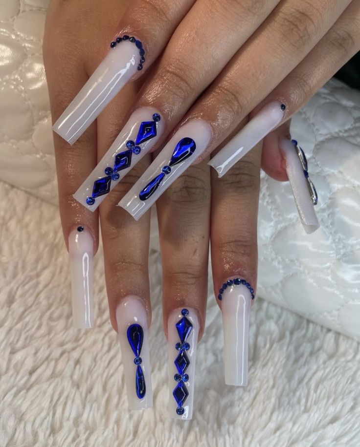 Sophisticated Long Clear Acrylic Nails with Glossy Finish and Intricate Blue Embellishments.