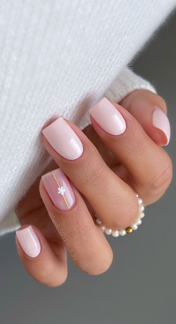 Sophisticated Soft Pink Nail Design with Delicate Floral and Gold Accents.