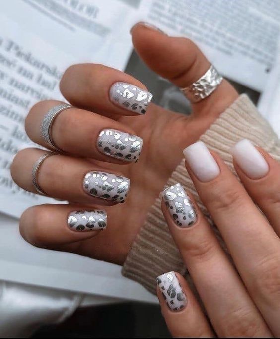 Chic Metallic Silver Hearts on Glossy White Nail Design: A Playful Yet Sophisticated Look.