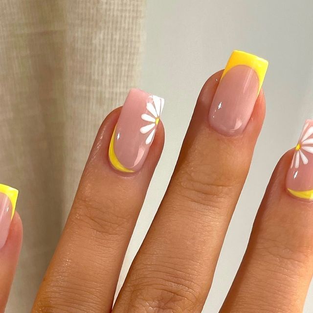 Spring-Inspired Nail Design: Soft Pink with Cheerful Yellow Tips and Delicate Daisy Accents.