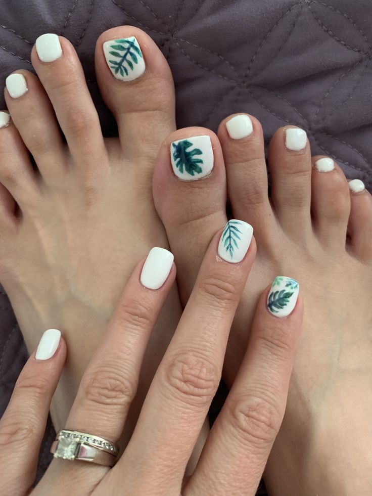 Chic Botanical Elegance: Fresh White Nail Design with Green Leaf Accents.