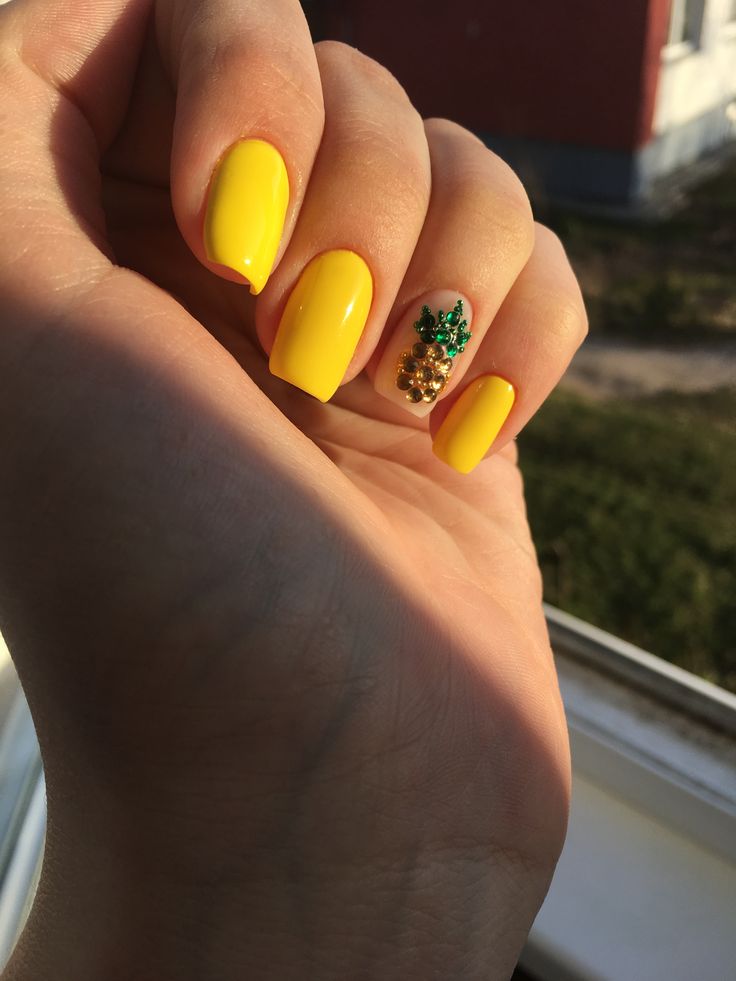 Vibrant Yellow Manicure with Playful Pineapple Accent Nail and Glossy Finish.