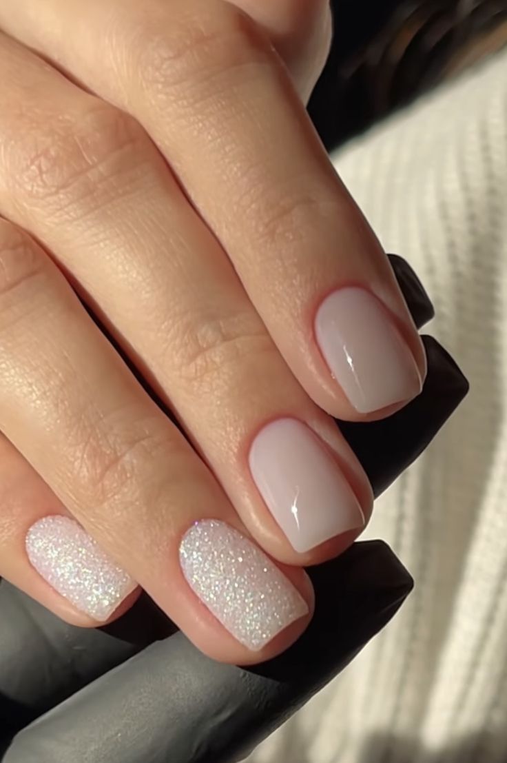 Elegant Pastel Nail Design: Delicate Pink Base with Sparkling Glitter Accent.