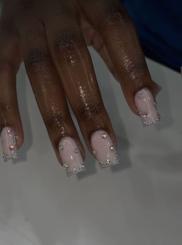 Sophisticated Nude Nail Design with Sparkling Rhinestones and Glitter Tips.