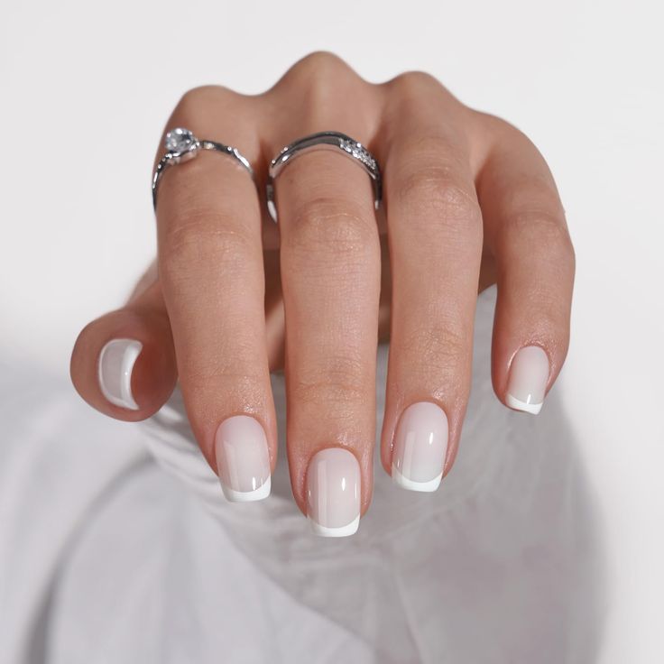 Sophisticated French Manicure with Translucent Nude Polish and Silver Accents.