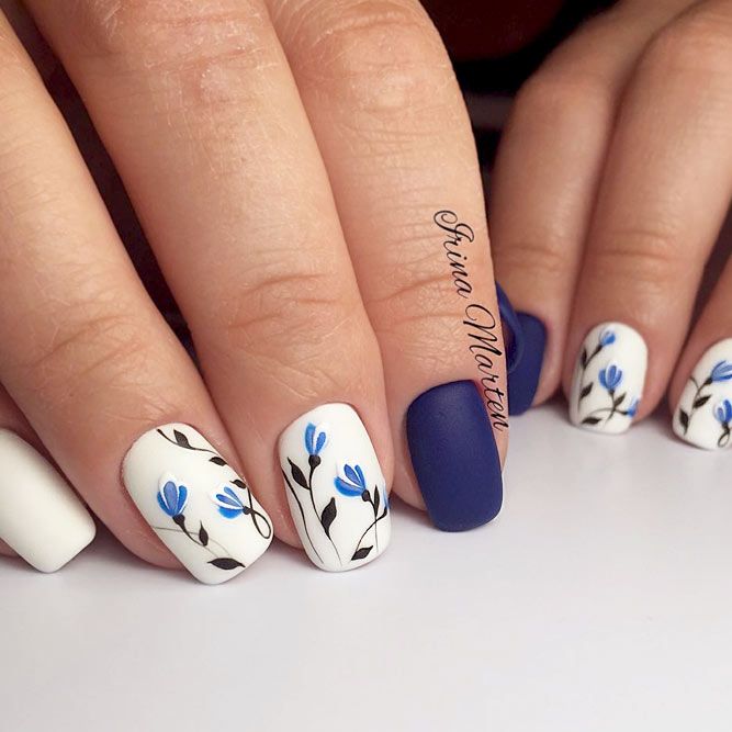 Elegant Matte Floral Nail Design with Delicate Blue Flowers and Striking Navy Contrast.