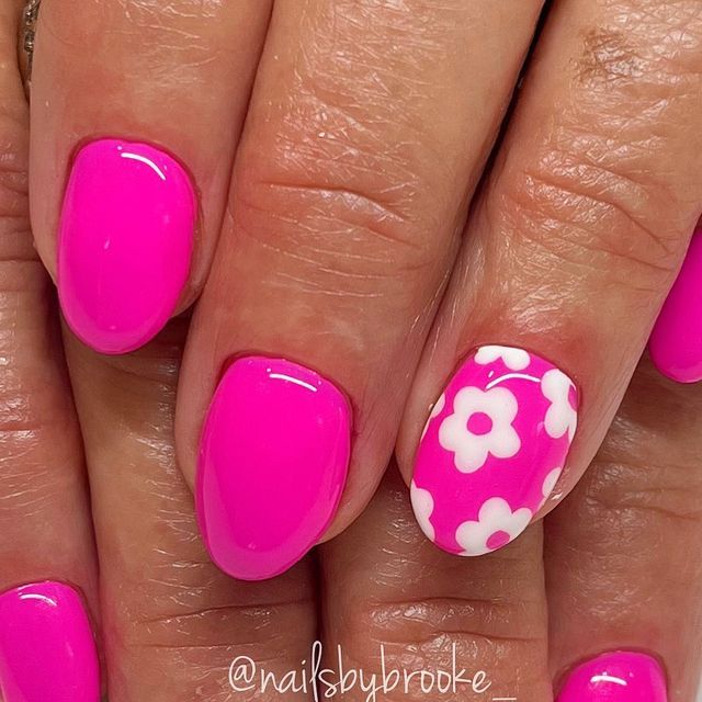 Playful Pink Nail Design with Glossy Finish and Floral Accents for a Whimsical Look.