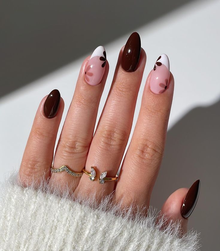 Trendy Chic Nail Design: Glossy Almond Shape with Deep Brown, Soft Pink, and Whimsical Floral Accents.