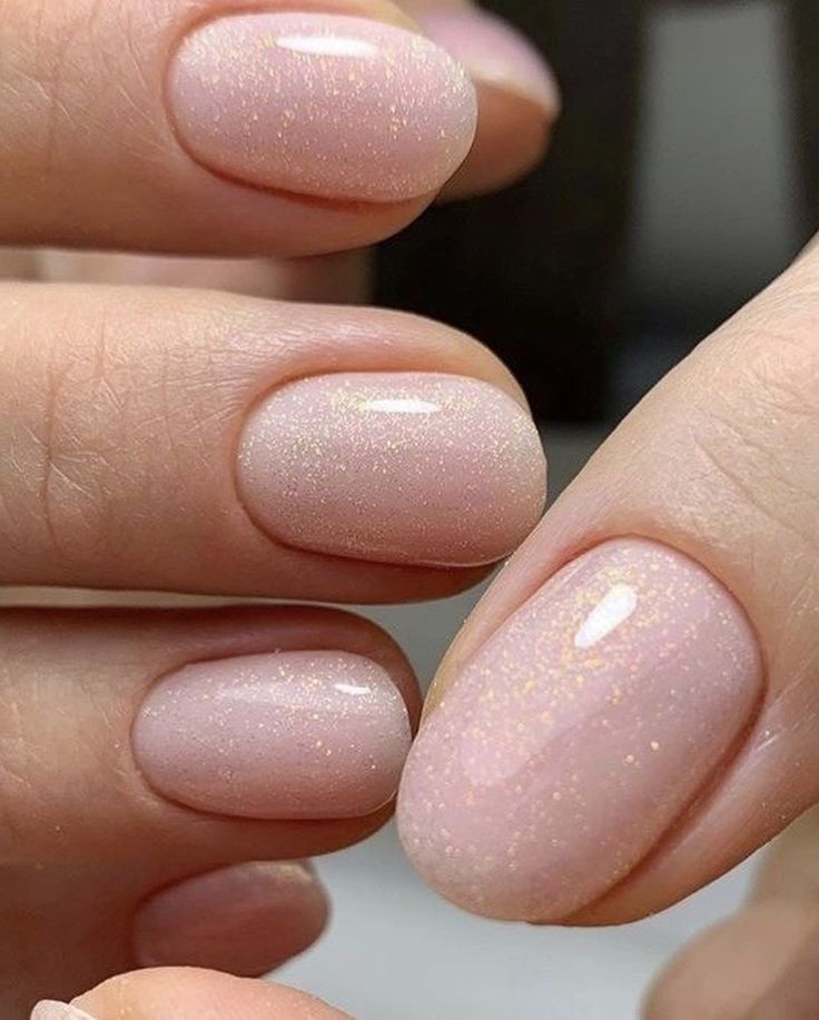 Elegant Shimmering Pink Nail Design with Delicate Sparkle and Feminine Shapes.