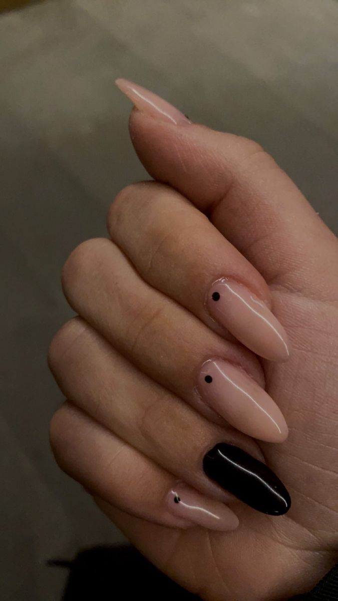 Chic Almond-Shaped Nails: A Soft Nude Base with Striking Black Accents and Playful Dots.