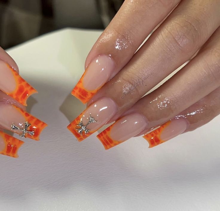 Chic French Manicure with Vibrant Orange Tips and Glamorous Sparkling Embellishments.