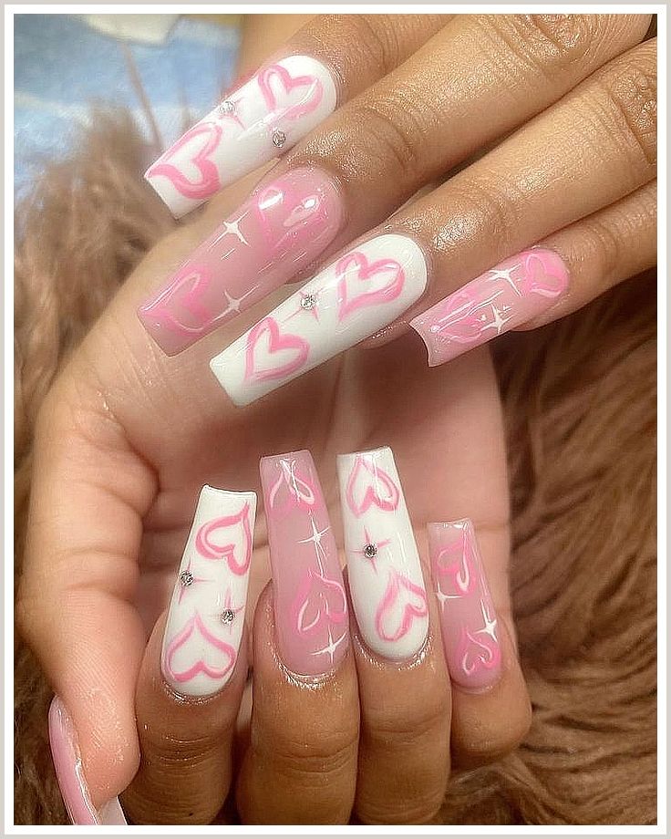 Charming Heart-Themed Nail Design in Soft Pink and White with Intricate Patterns and Sparkling Rhinestones