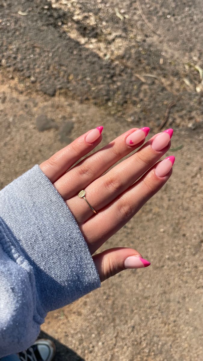 Chic Almond-Shaped Nail Design with Neutral Tones, Vibrant Pink Tips, and Whimsical Heart Details.